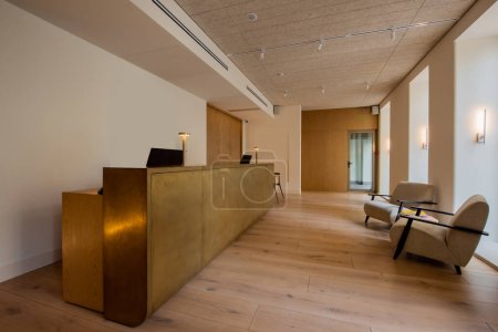 Téléchargez les photos : Modern armchairs near reception desk in luxury hotel lobby - en image libre de droit