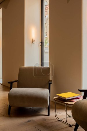 modern armchairs near books on coffee table in luxury hotel lobby 