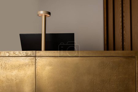 computer monitor near modern golden lamp on reception of luxury hotel 