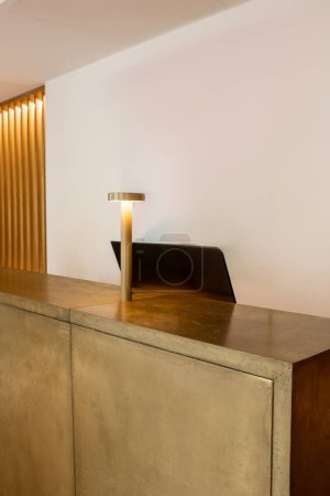 computer monitor near golden lamp on reception desk of luxury hotel 
