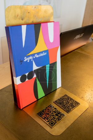 art book at reception desk with qr code and computer monitor 