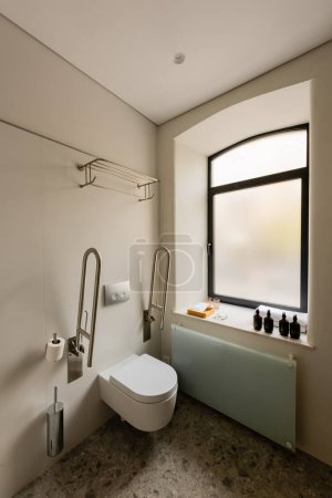 Foto de Interior of white bathroom with toilet for disabled people in hotel - Imagen libre de derechos