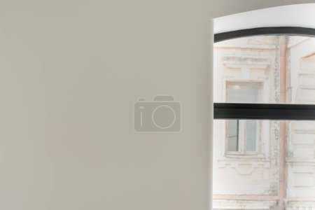 Photo for Grey wall next to window with view on aged building from hotel - Royalty Free Image