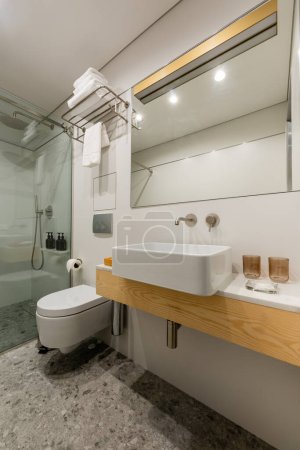 interior of modern bathroom with white clean glasses near sink