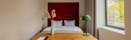 Téléchargez les photos : Wooden desk and chair near comfortable bed in hotel room, banner - en image libre de droit