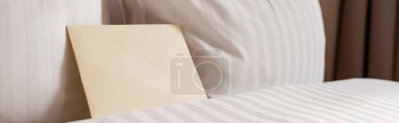 Foto de Blank envelope on white and clean bedding in hotel room, banner - Imagen libre de derechos