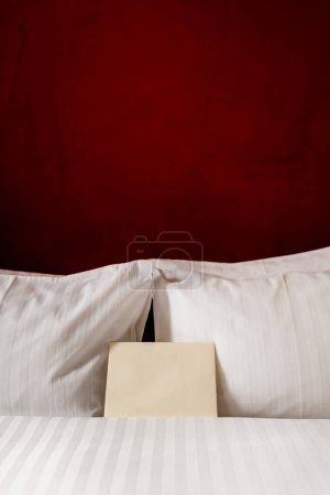 Foto de Blank envelope on white and clean bedding in hotel room - Imagen libre de derechos