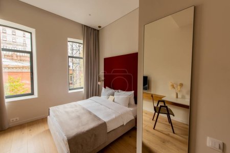 Photo for Envelope on comfortable bed near mirror in hotel room - Royalty Free Image