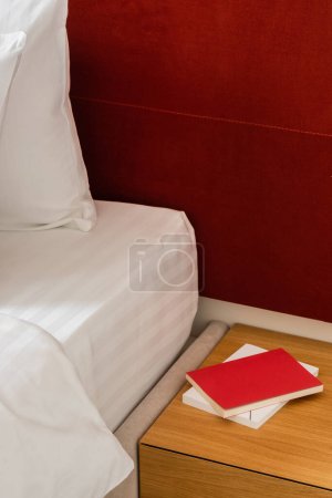 Foto de Books on bedside table near modern bed in hotel - Imagen libre de derechos