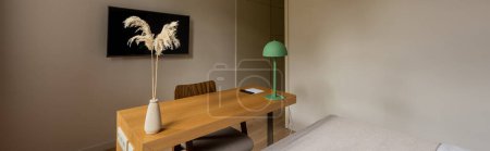 Foto de Wooden desk and tv with blank screen on wall near bed in room of hotel, banner - Imagen libre de derechos