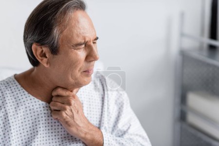 Elderly patient suffering from throat pain in clinic