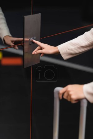 Photo pour Cropped view of woman pressing elevator call button in hotel - image libre de droit