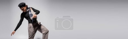 young african american guy in trendy casual attire posing on grey background, banner