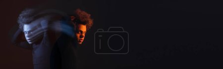 Foto de Doble exposición del hombre afroamericano herido y deprimido con trastorno bipolar sobre fondo oscuro con luz naranja y azul, pancarta - Imagen libre de derechos