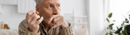 Photo for Senior man with parkinson disease and trembling hands looking away at home, banner - Royalty Free Image