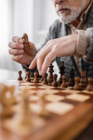 Téléchargez les photos : Partial view of senior man with alzheimer syndrome playing chess at home - en image libre de droit
