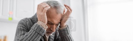 Photo for Senior man suffering from azheimers disease and headache while holding hands near head, banner - Royalty Free Image