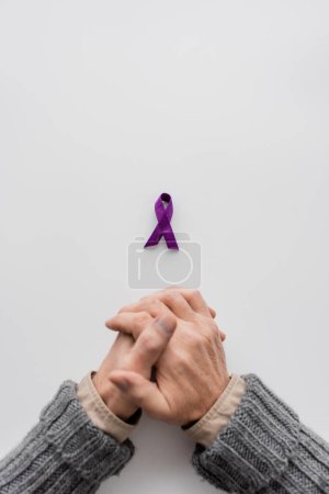 top view of cropped senior man near purple alzheimer disease awareness ribbon on white background with copy space