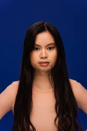 Photo for Portrait of long haired asian model isolated on navy blue - Royalty Free Image