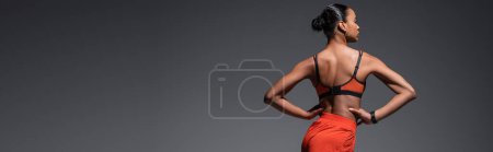 Photo for Young african american woman in sportswear exercising with hands on hips isolated on grey, banner - Royalty Free Image