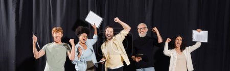 Photo for Excited multiracial actors holding screenplays and celebrating triumph near mature art director, banner. Translation of tattoo: om, shanti, peace - Royalty Free Image