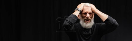 Photo for Frustrated tattooed actor holding hands on head while playing dramatic role in theater, banner - Royalty Free Image