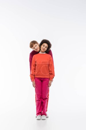 cheerful interracial couple in magenta color clothes showing i letter on white background 