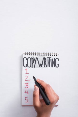 Photo for Top view of man holding marker near notebook with copywriting lettering on table - Royalty Free Image