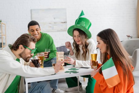 Multiethnic friends celebrating saint patrick day and playing wood blocks game at home 