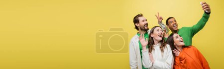 Téléchargez les photos : Positive interracial friends gesturing while having video chat isolated on yellow, banner - en image libre de droit