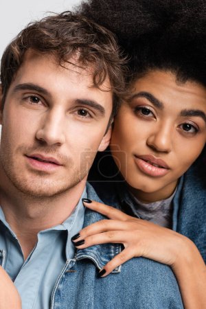 Téléchargez les photos : Portrait of curly african american woman and good looking man looking at camera isolated on grey - en image libre de droit