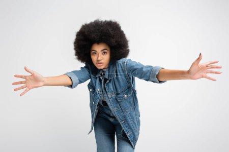 Photo for Young african american woman in jeans and denim clothes looking at camera isolated on grey - Royalty Free Image