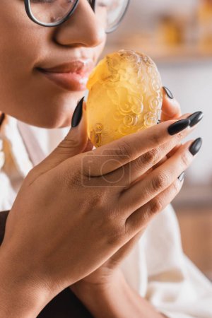cropped view of african american craftswoman enjoying flavor of homemade soap 