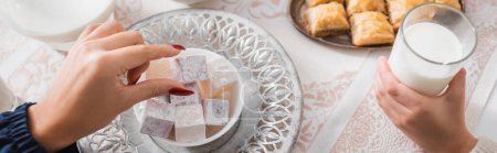 Photo for Top view of muslim woman taking turkish delight near child with milk during ramadan morning, banner - Royalty Free Image