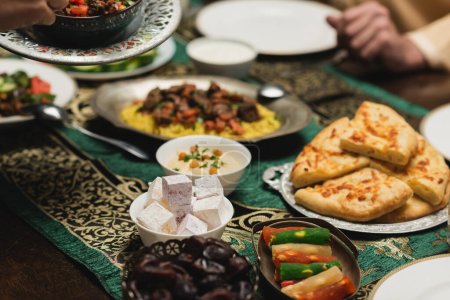 Téléchargez les photos : Vue sur les cultures de délicieux aliments près de la famille musulmane pendant le dîner du ramadan - en image libre de droit
