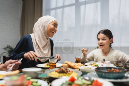 Photo for Smiling middle eastern family having iftar dinner during ramadan - Royalty Free Image
