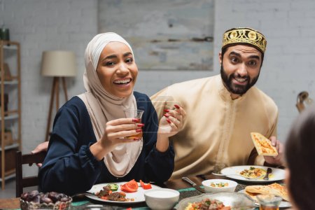 Foto de Familia de Oriente Medio hablando cerca de la cena durante el ramadán en casa - Imagen libre de derechos