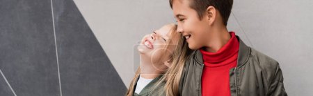 glückliche und gut gekleidete Kinder in Bomberjacken lächeln, während sie in der Nähe von Einkaufszentrum stehen, Banner 
