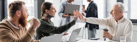 Positive business people giving high five near colleagues during training in office, banner 