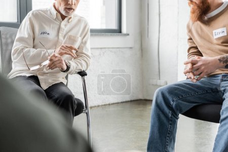 Vista recortada del hombre maduro con problemas para compartir adicción al alcohol en el centro de rehabilitación 