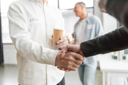 People with alcohol addiction shaking hands in recovery center 