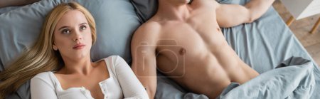 Téléchargez les photos : Vue grand angle de la femme embarrassée se réveillant avec un homme torse nu après une table de nuit, bannière - en image libre de droit