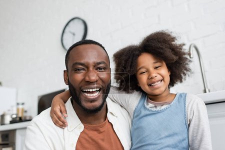 Porträt eines freudigen afrikanisch-amerikanischen Vaters und eines glücklichen Kindes, das in die Kamera blickt 