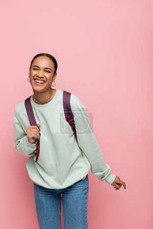 Photo for Smiling young african american student standing isolated on pink - Royalty Free Image