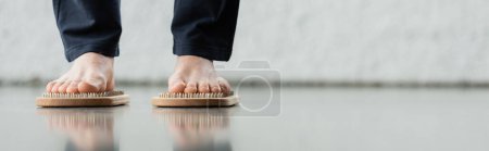 Photo for Partial view of man in pants standing on sadhu nail board in yoga studio, banner - Royalty Free Image