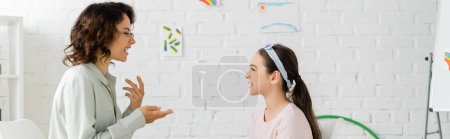 Photo for Side view of speech therapist talking to preteen girl in consulting room, banner - Royalty Free Image