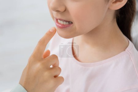 Foto de Vista recortada del terapeuta del habla apuntando a los labios del niño durante la lección en la sala de corrección - Imagen libre de derechos
