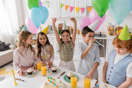 Gruppe und glückliche Kinder in Partymützen haben Spaß beim Geburtstag zu Hause 