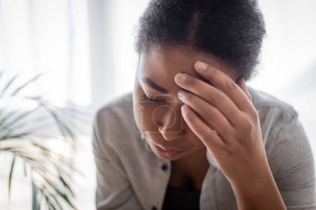 Young multiracial woman suffering from headache at home 