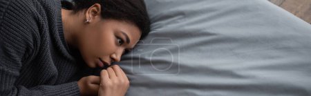 Photo for Top view of depressed multiracial woman with apathy looking away on bed, banner - Royalty Free Image